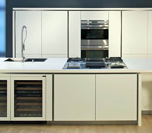 Functional architectural kitchen with handle-less design, double oven and below-the-counter wine cooler; modular cooking range and downdraft exhaust hood with circulating air fans from the premium manufacturer Subzero-Wolf; detail of the miter manufacturing